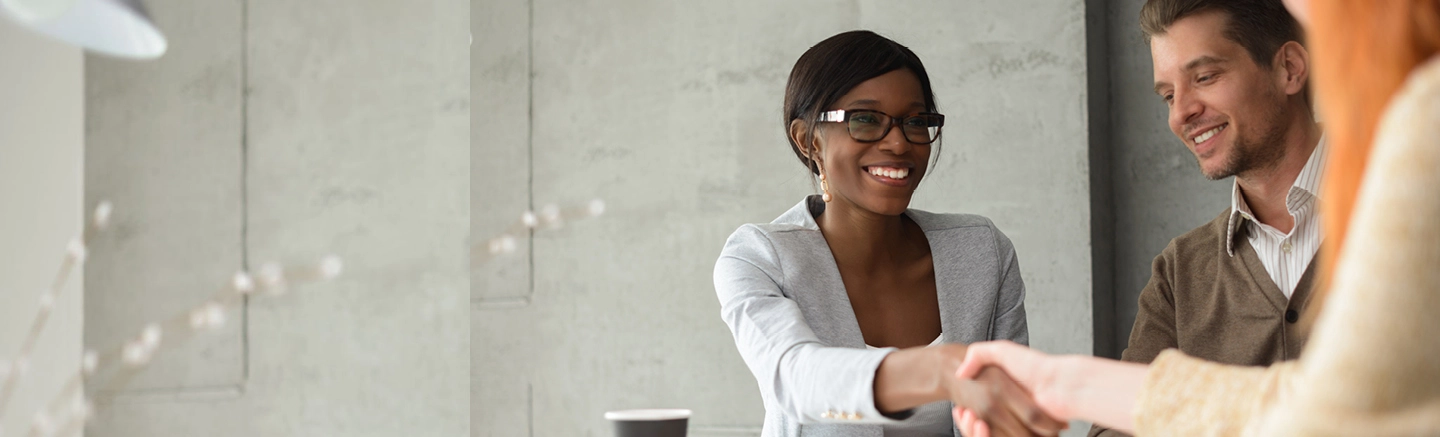 Black woman shaking hands with red hair woman