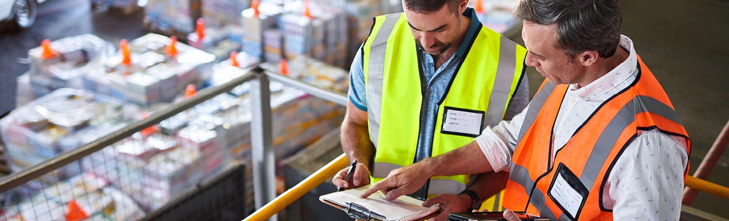 Men in warehouse looking at clipboard