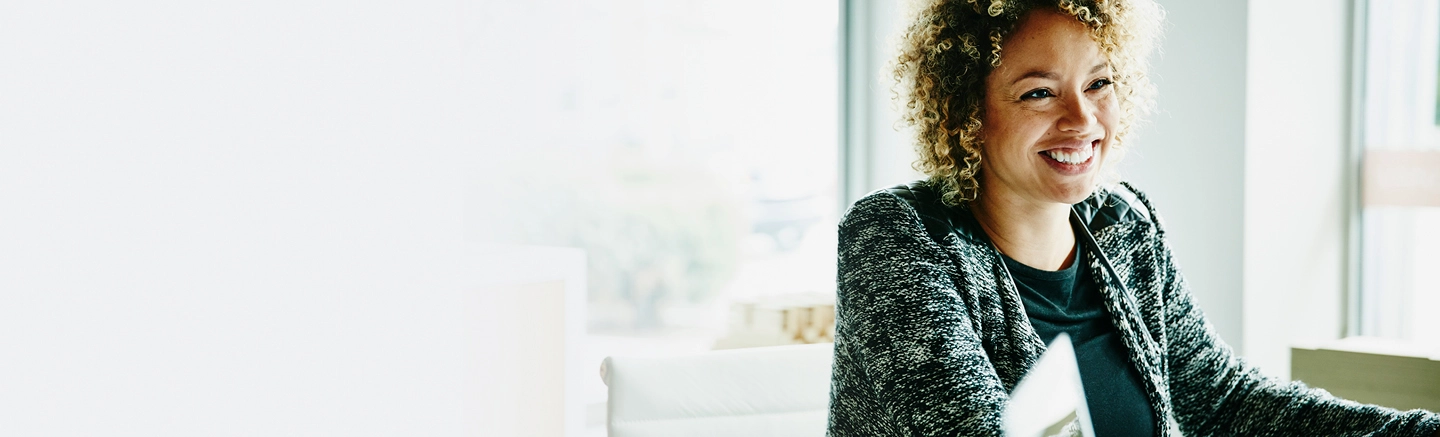 Black Woman in tweed jacket smiling 