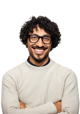 A smiling man with crossed arms, glasses a cream-colored sweater and curly hair.