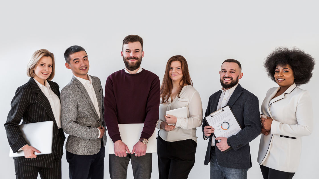 A group of people in formal work attire holding laptops and folders and a clipboard with some data printed on it.
