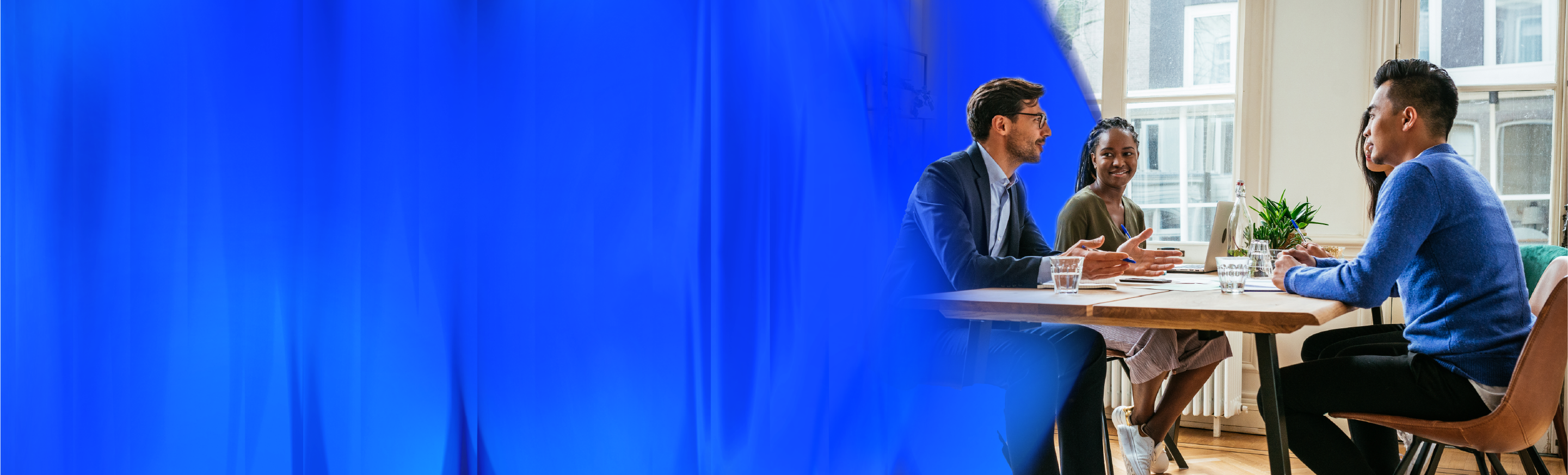 A team has a meeting and discuss among themselves. On the left, we have a blue background.