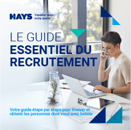 Une femme parle au téléphone tout en travaillant sur son ordinateur portable. En bleu, les mots 
